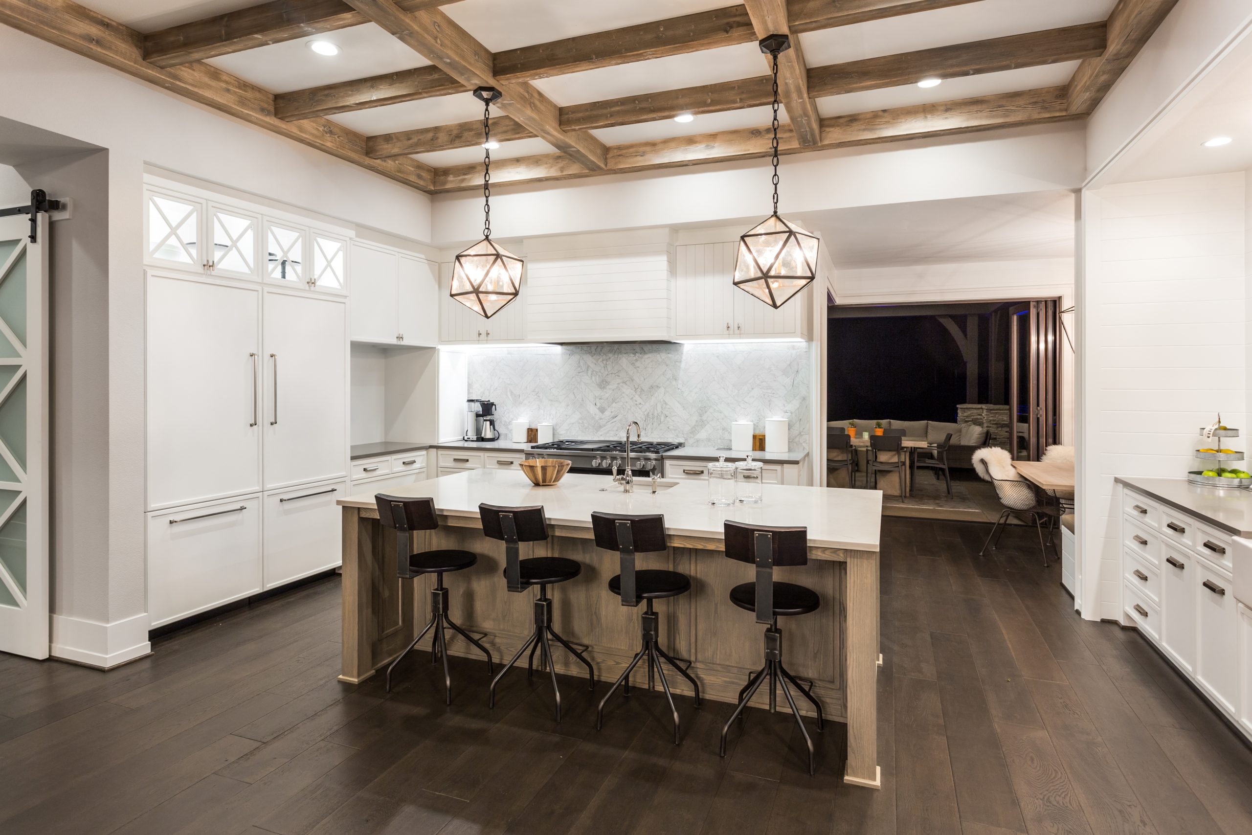 beautiful kitchen in new luxury home with island, pendant lights, and hardwood floors