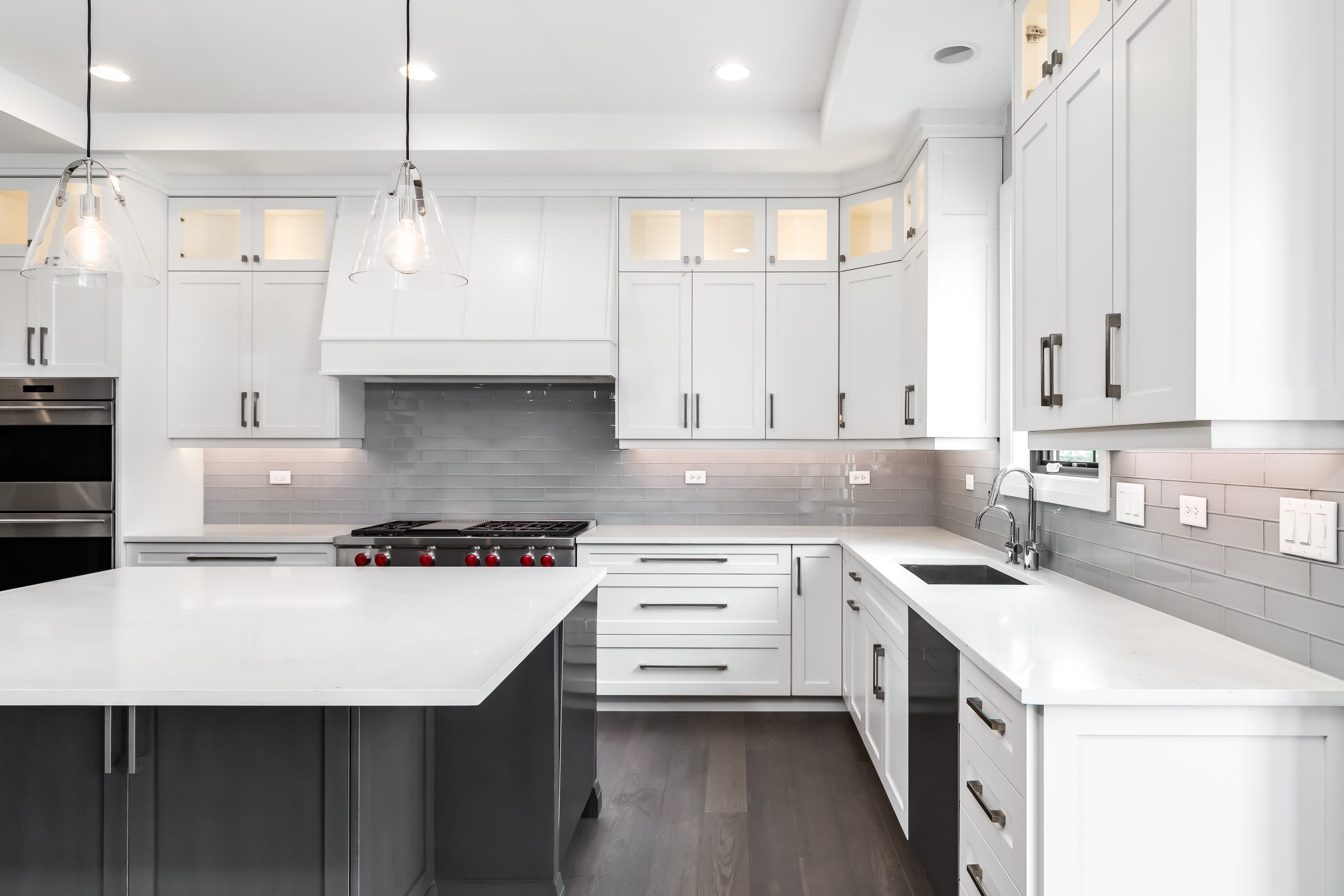 A modern kitchen with white cabinets, a large island, and stainless steel appliances.